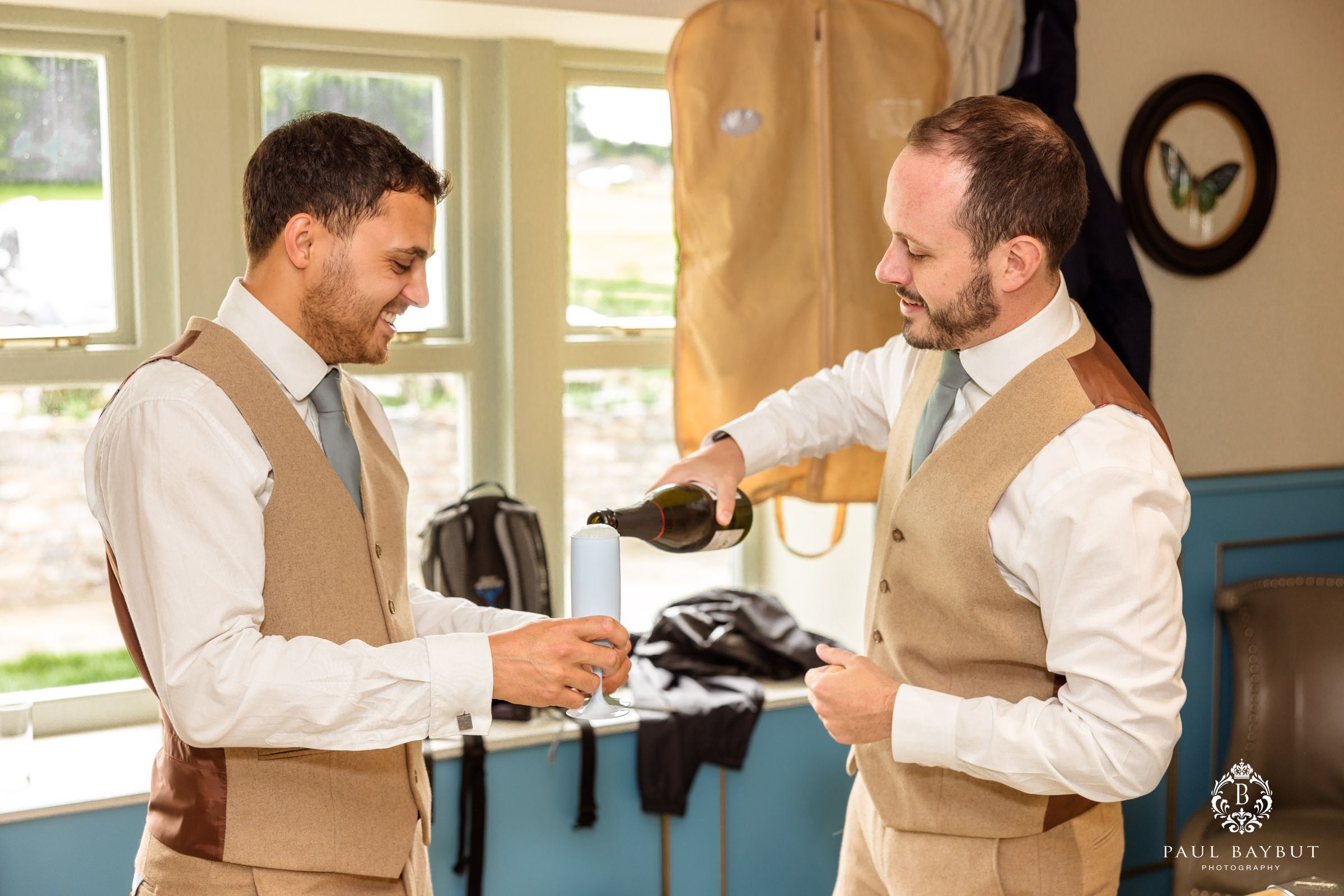 Pre-wedding preparation scene showing two people helping each other get ready in formal attire.