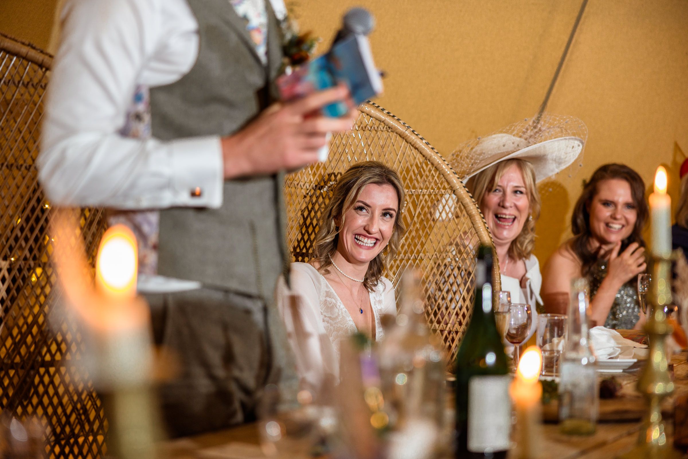 Candlelit reception dinner with peacock chair and joyful guests.