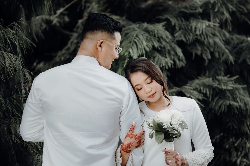 Bride holding on arms of groom in a nice greenery background