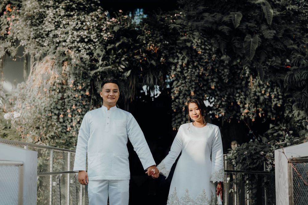 Newly weds holding hand while sun rays beam from the left side of the image