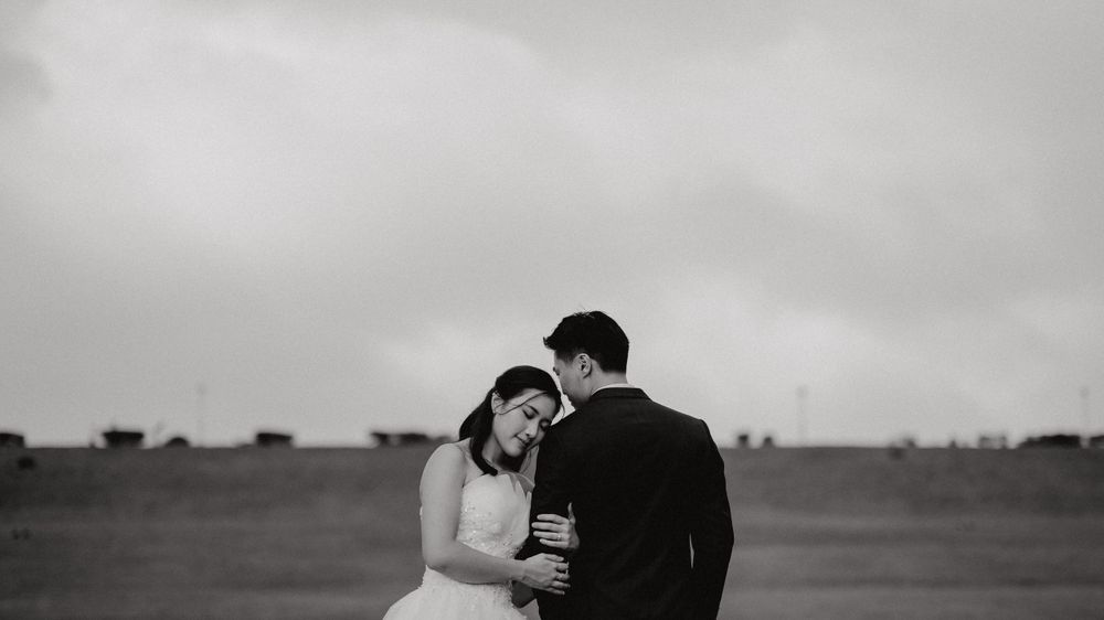 Bride resting head on groom with a black and white filter