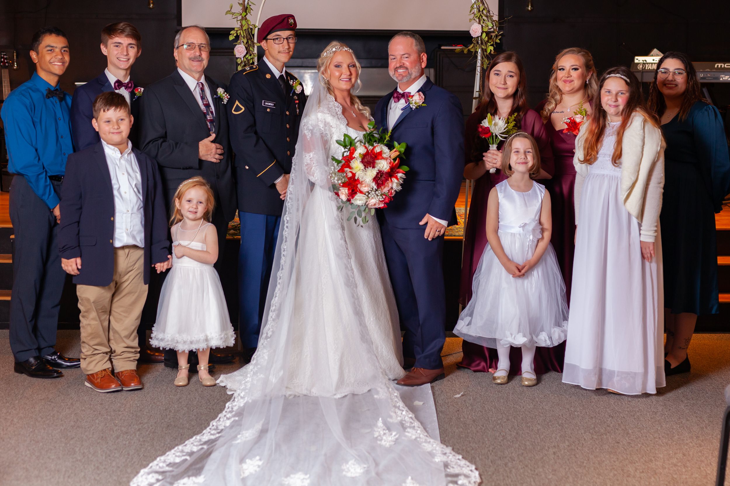 Indoor wedding ceremony group photo with guests and wedding party.
