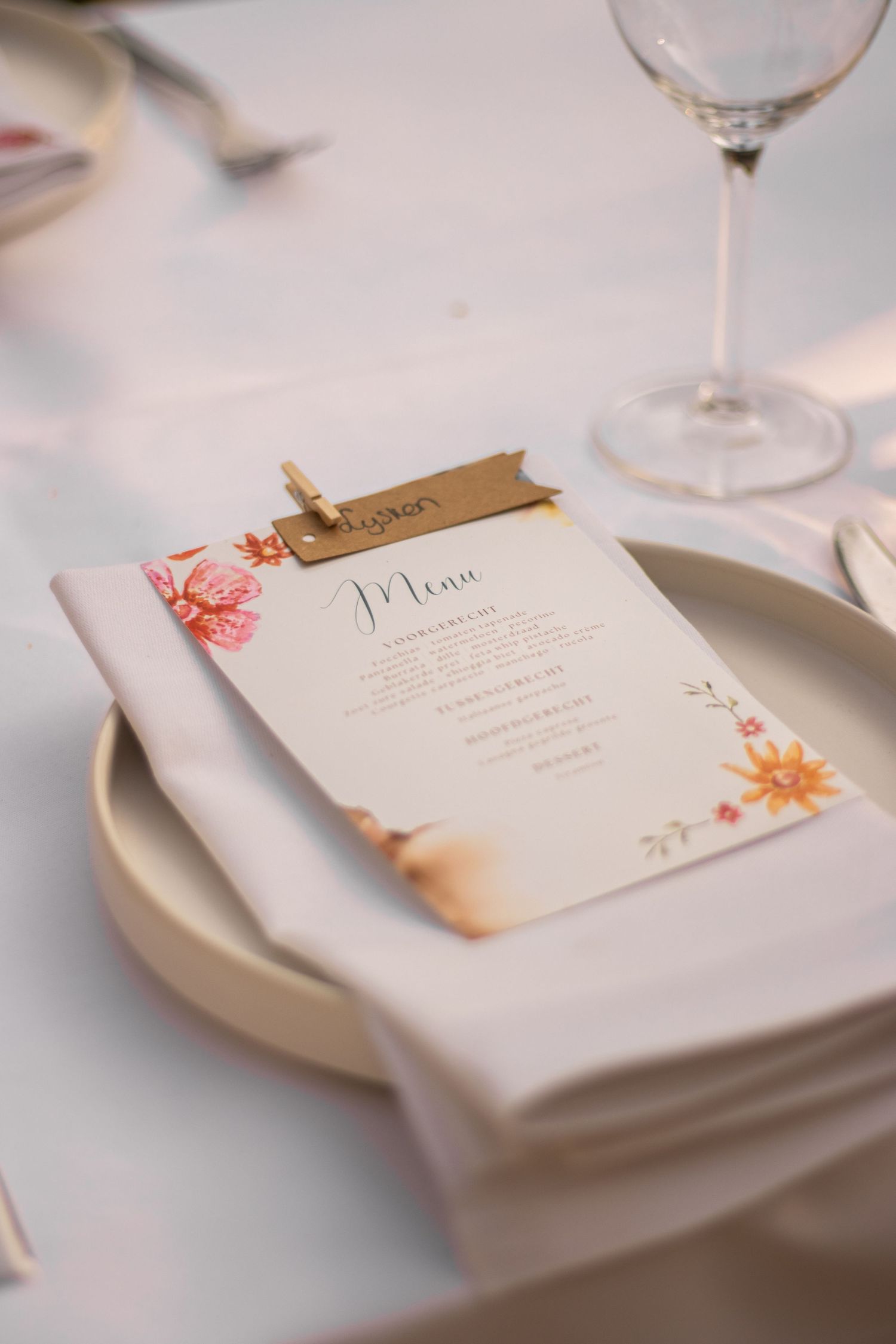 Opgedekte tafel voor een 21-diner, met gepersonaliseerde menukaart, servet en wijnglas