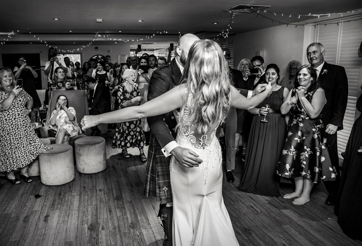 Black and white photos capture dancing and celebration at a lively wedding reception.