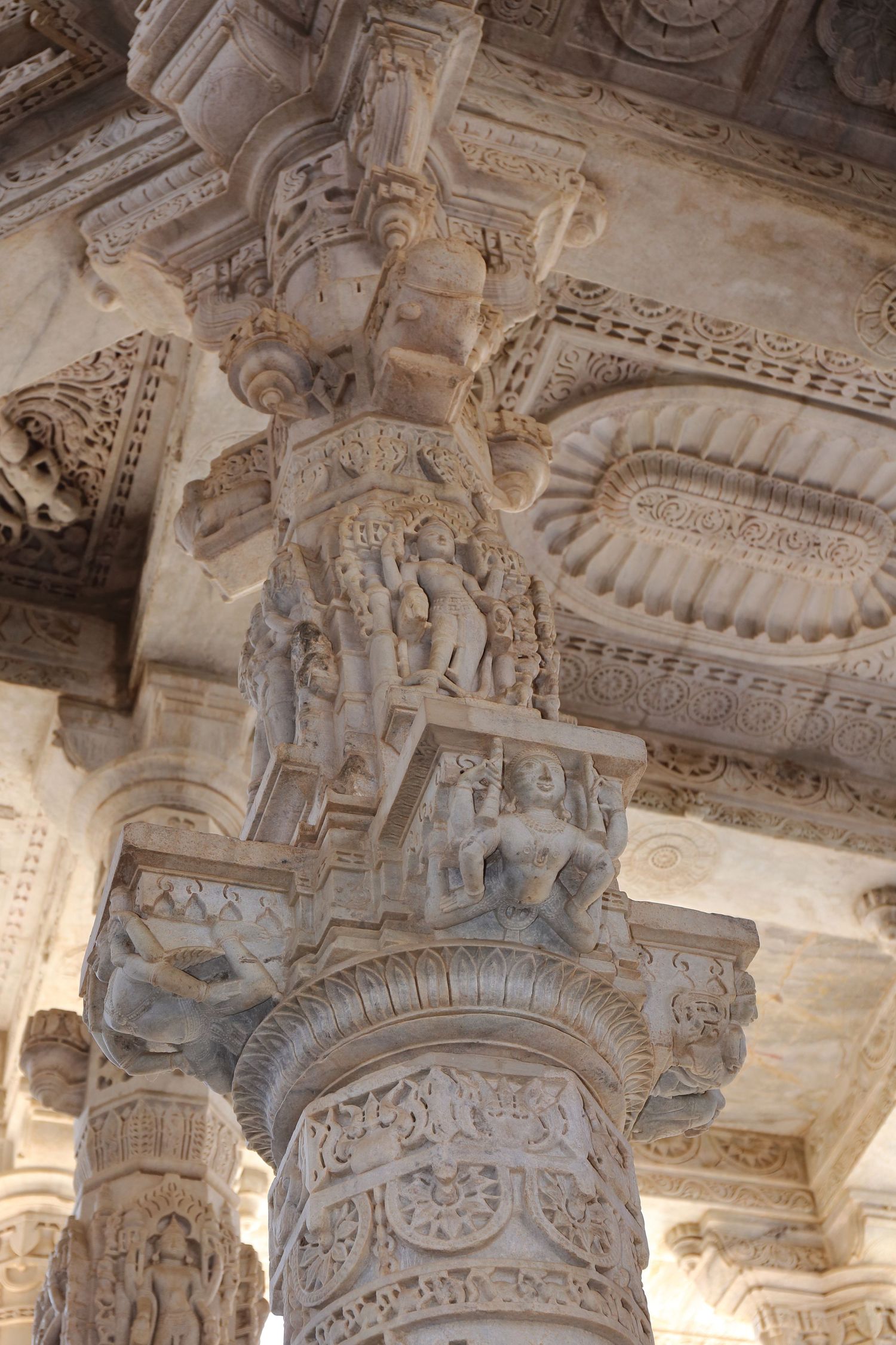 Intricately carved stone pillar with detailed sculptures and ornamental designs in Indian architecture.