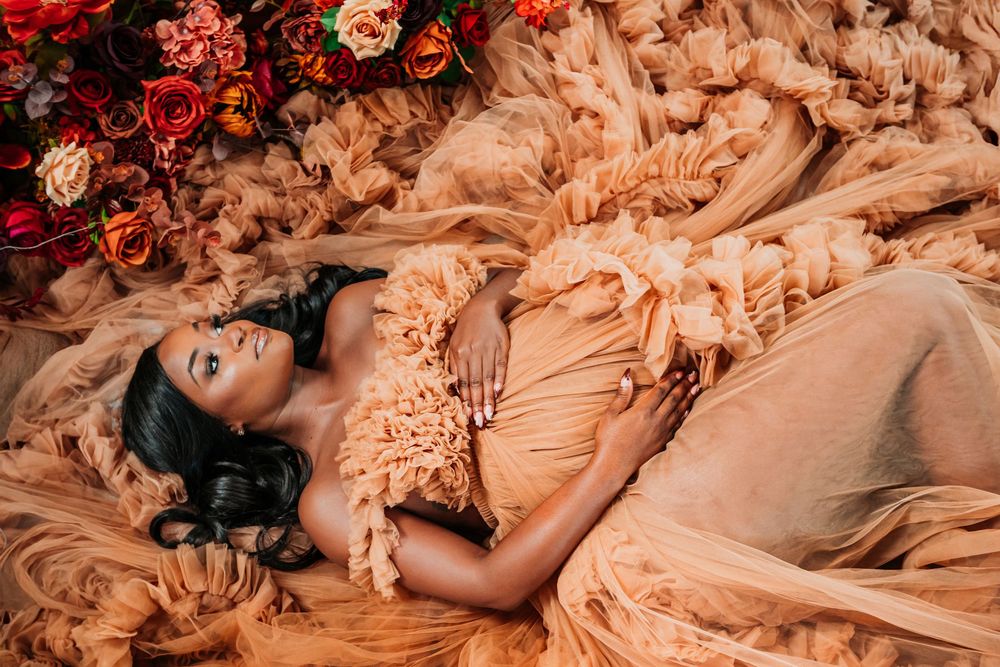 A collection of romantic maternity photos showing delicate floral arrangements and flowing fabric in warm peach tones.