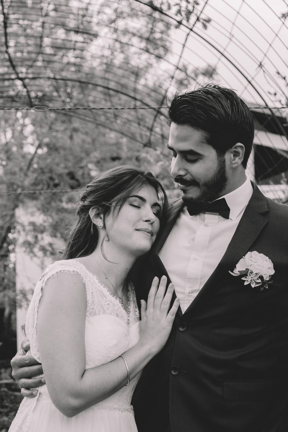 Romantic black and white portrait of newlyweds embracing outdoors.