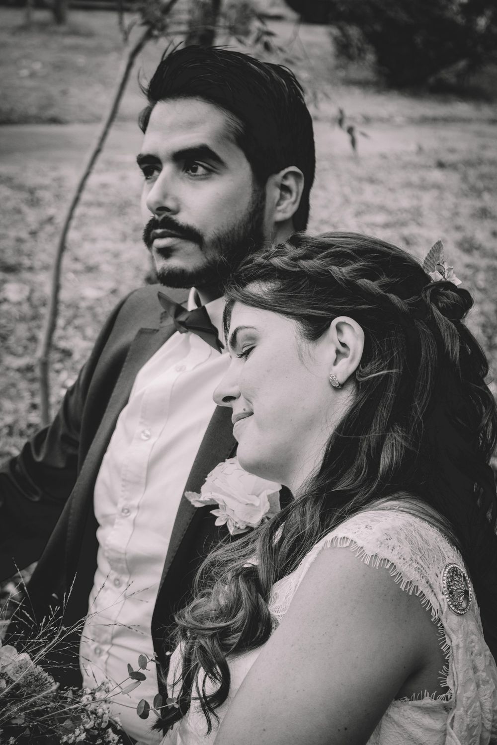 Wedding couple in black and white sharing an intimate moment outdoors.