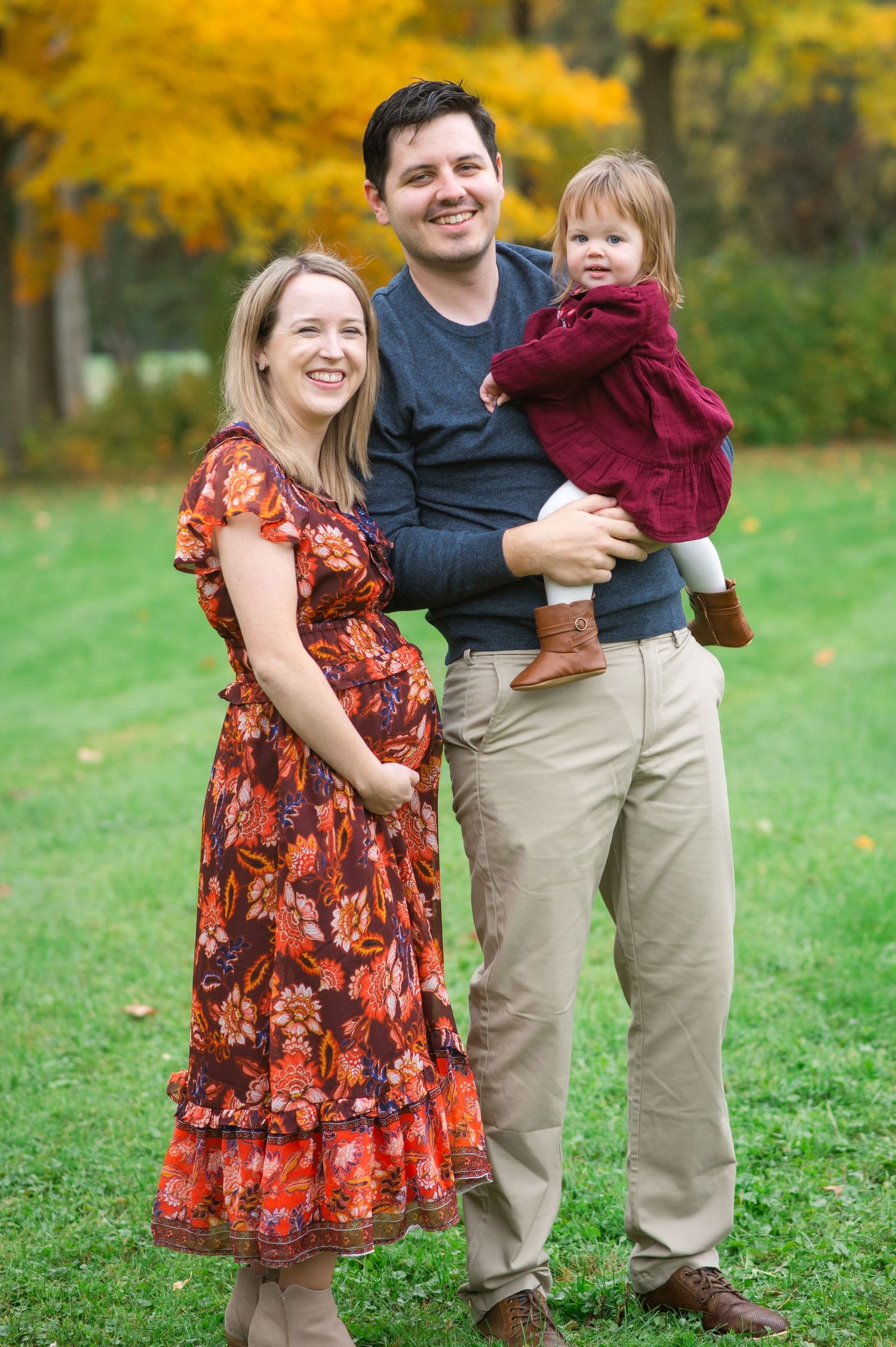 Autumn outdoor portrait with fall foliage featuring coordinated family outfits.