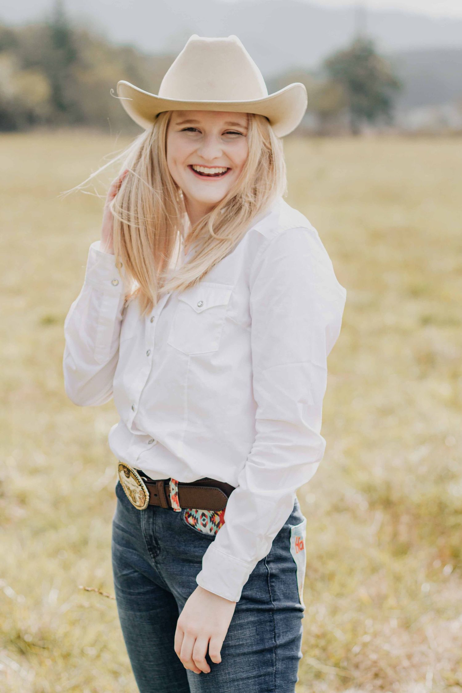 Blissful cowgirl getting her senior photos taken