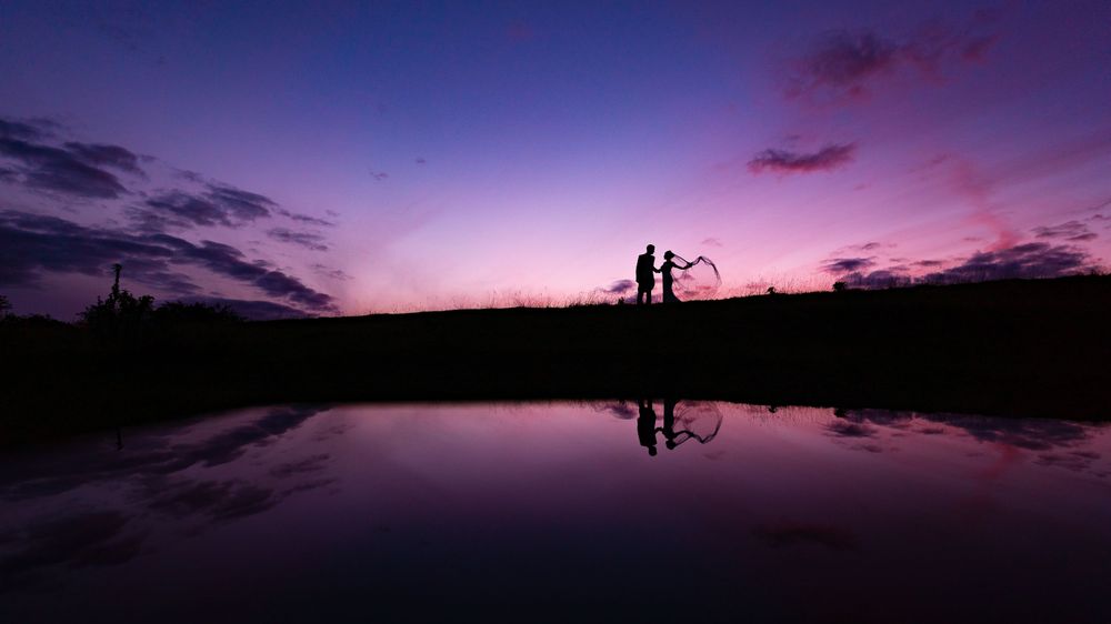 Purple and pink sunset sky reflected in still water creating a mirror effect.