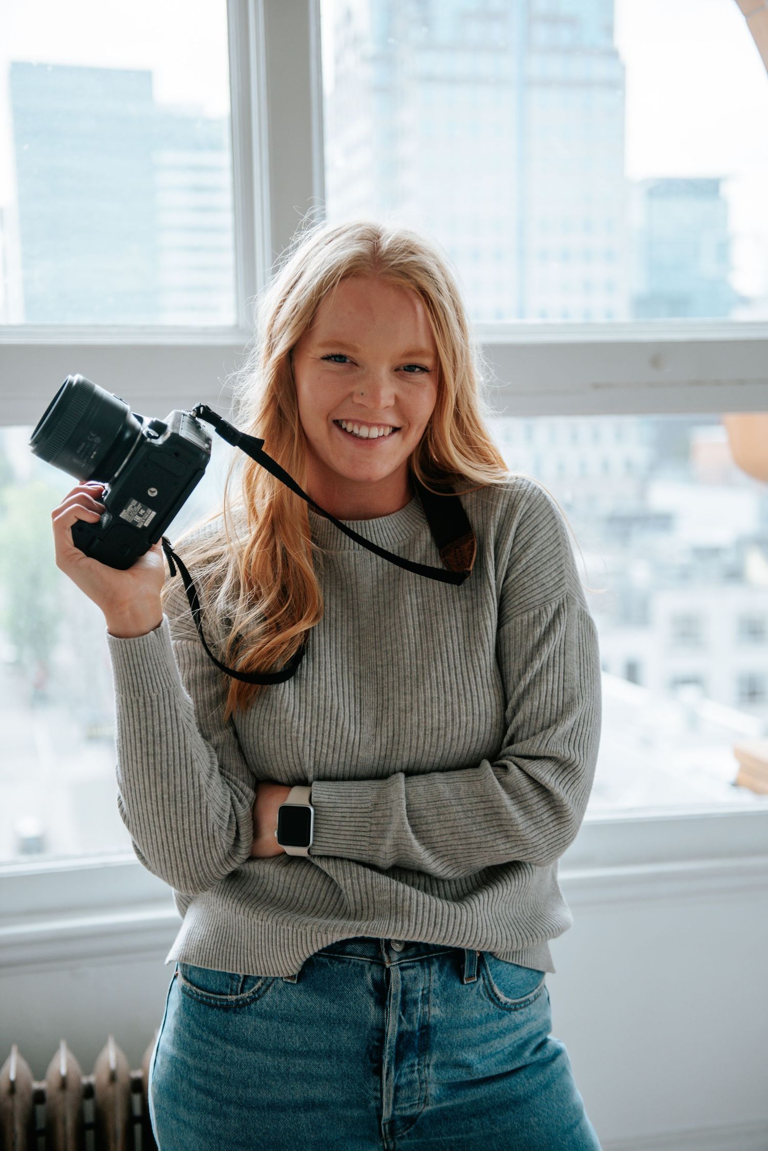 Photographer posed by window with camera