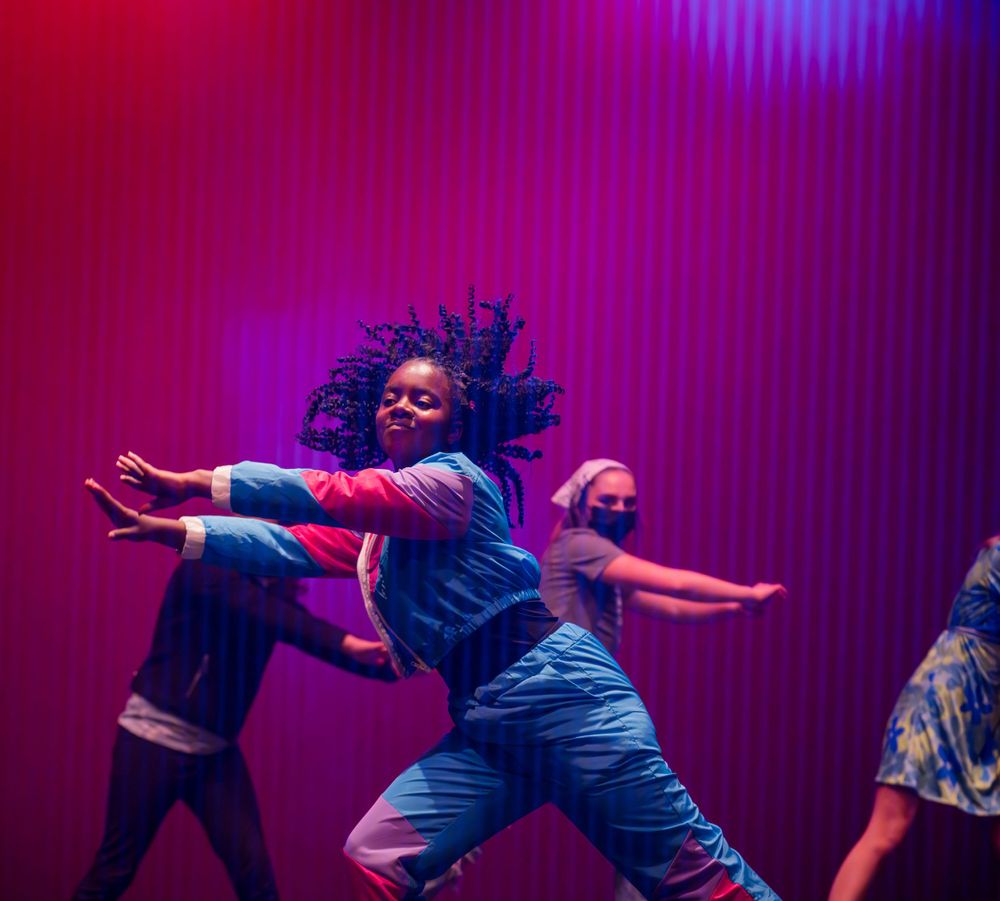 Dancers in bright, colorful lights during the 2023 Metamorphosis dance performance photographed by Sean Openshaw.