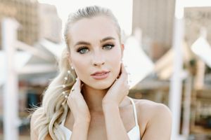 up close image of a beautiful bride's face with a downtown rooftop as the background setting.