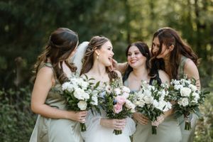 Bride with her bridesmaids laughing together during her spring time louisiana wedding