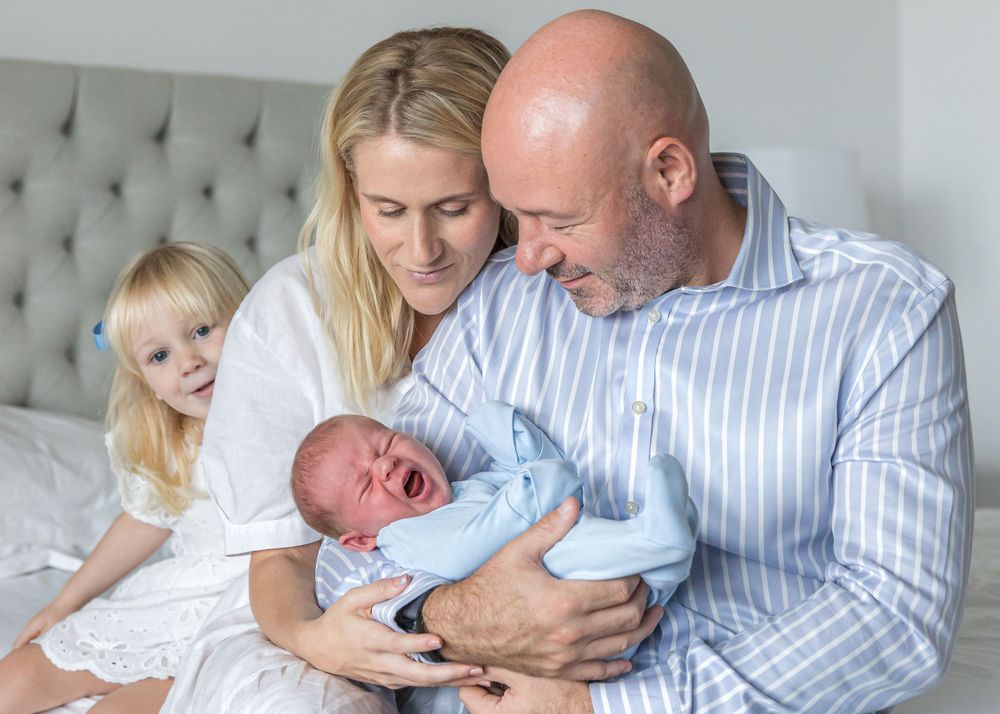 at-home newborn session on master bed - blue and white colour clothing