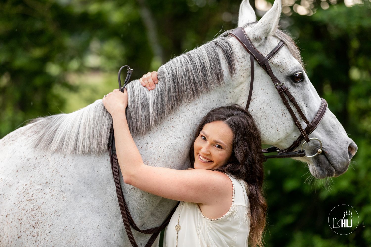 White horse and owner sharing tender moment against green background.