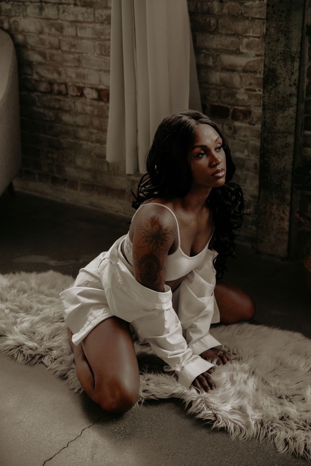 Sensual photography featuring relaxed poses on a plush white rug in an industrial setting.