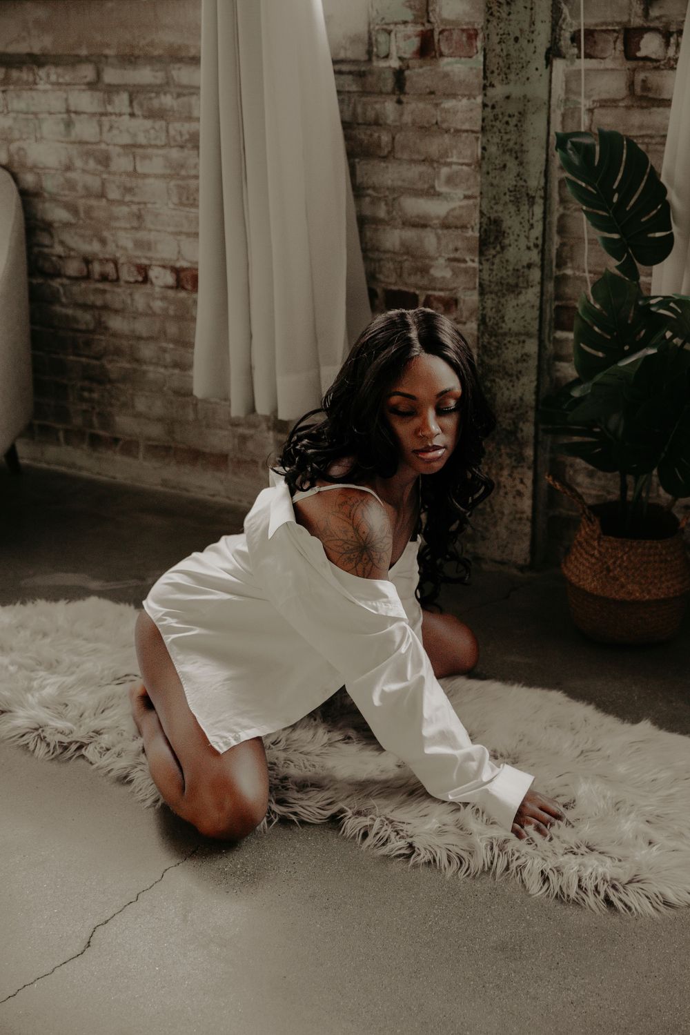 Artistic boudoir session with natural lighting and minimalist styling in a loft space.