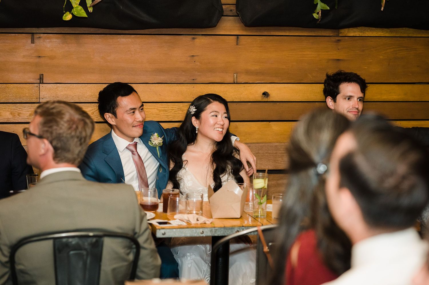 Wedding guests enjoying conversation at a rustic wooden reception venue.
