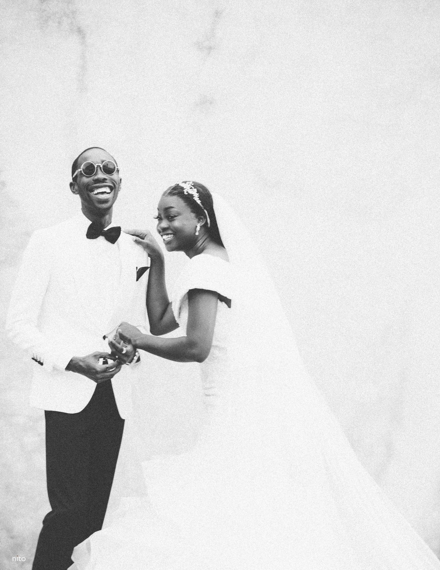 Black and white wedding photo capturing joyful moments in elegant attire.