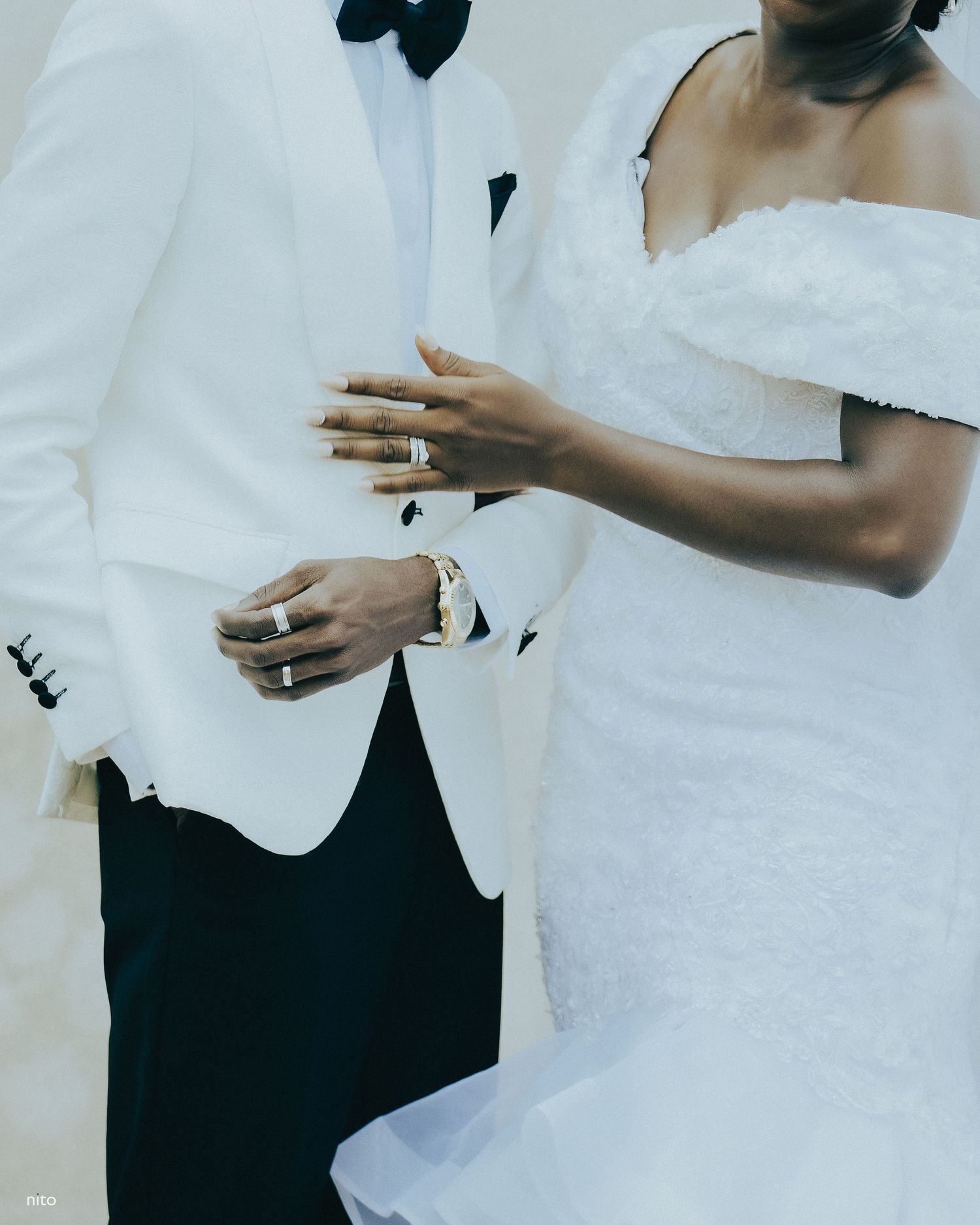 Close-up shot of wedding attire showing elegant white formal wear and delicate details.
