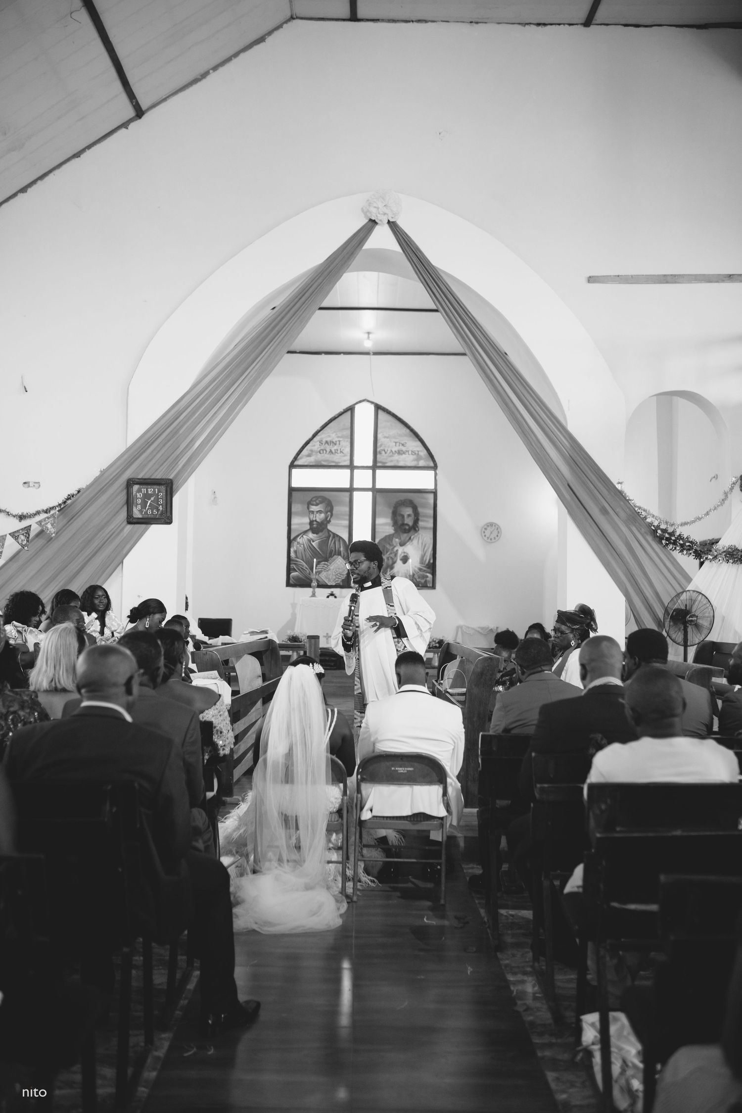 A traditional church wedding ceremony with draped fabric decorations and gathered guests.