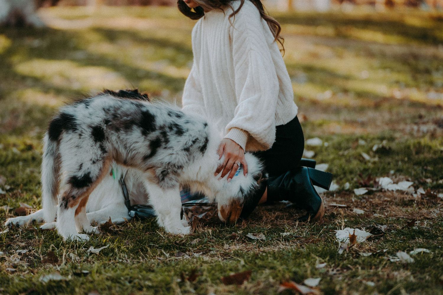Woman pets her dog showing off her radiant cut engagement ring at Mueller Lake Park