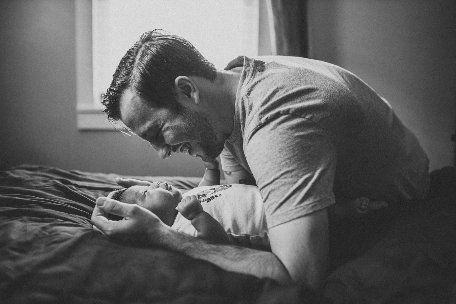 Baby boy and father play with one another