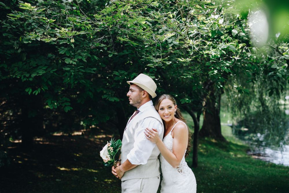 Newlyweds embrace in a lush green garden setting during their wedding photoshoot.