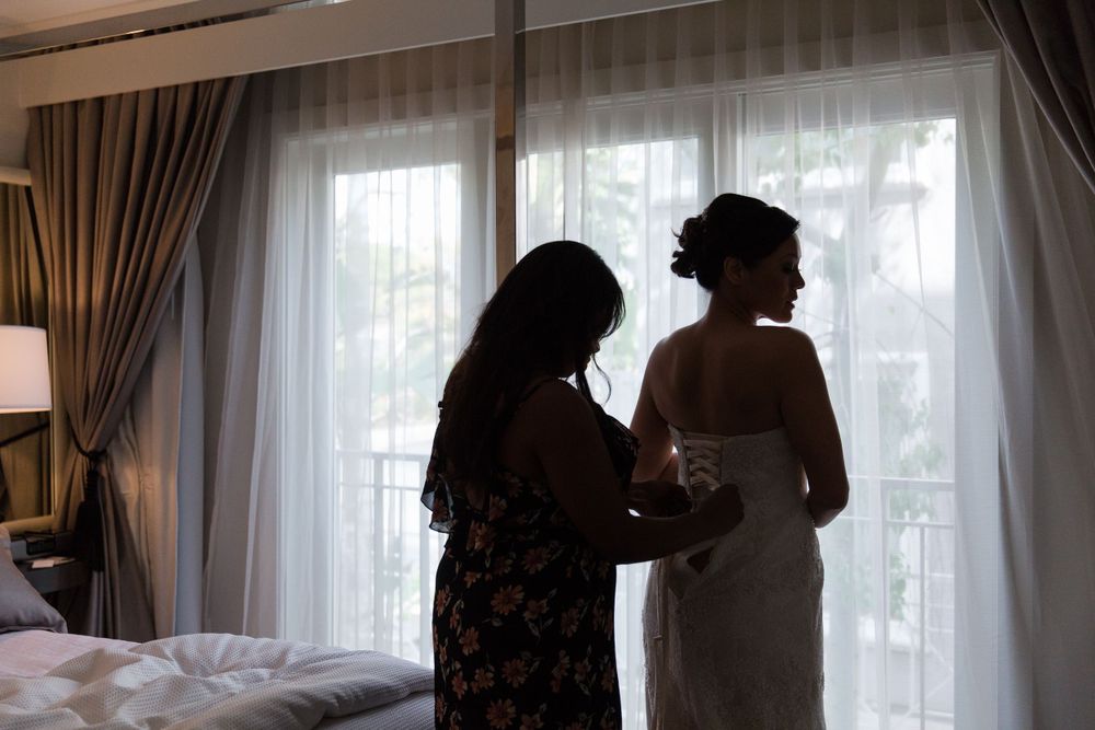 Silhouetted figures preparing for a wedding ceremony indoors.