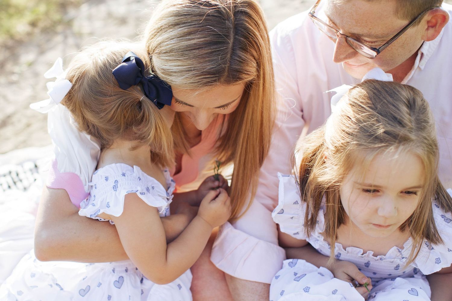 Seattle family session: A mother and father sit with their two daughters at Carkeek Park beach in Seattle