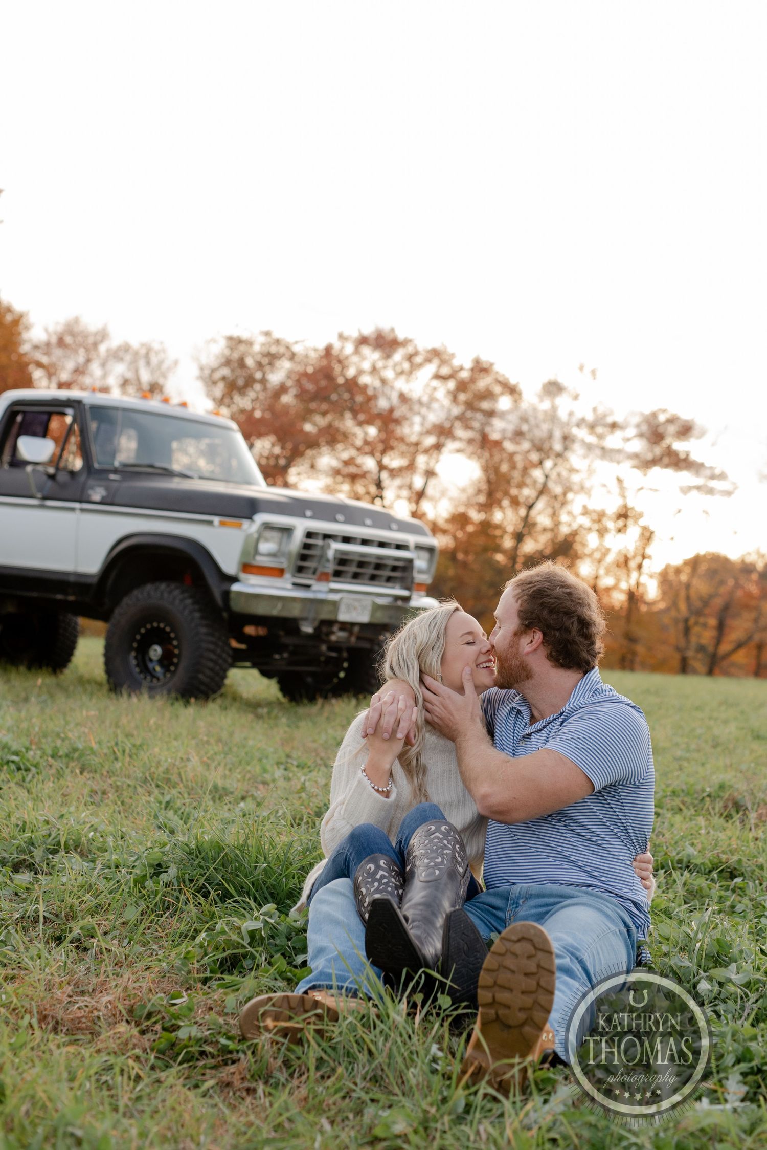 Romantic countryside photoshoot with a vintage Ford pickup truck in the background during golden hour.