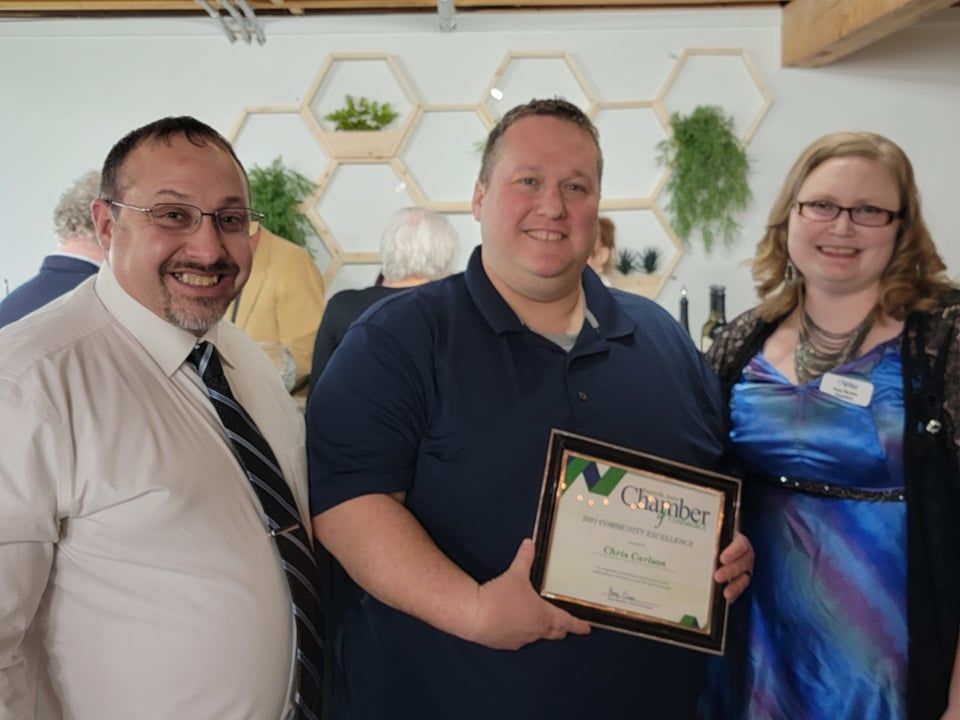 Chris holding Community Excellence award with Jeff Walls & Rose Backlin of Forsyth Chamber of Commerce.