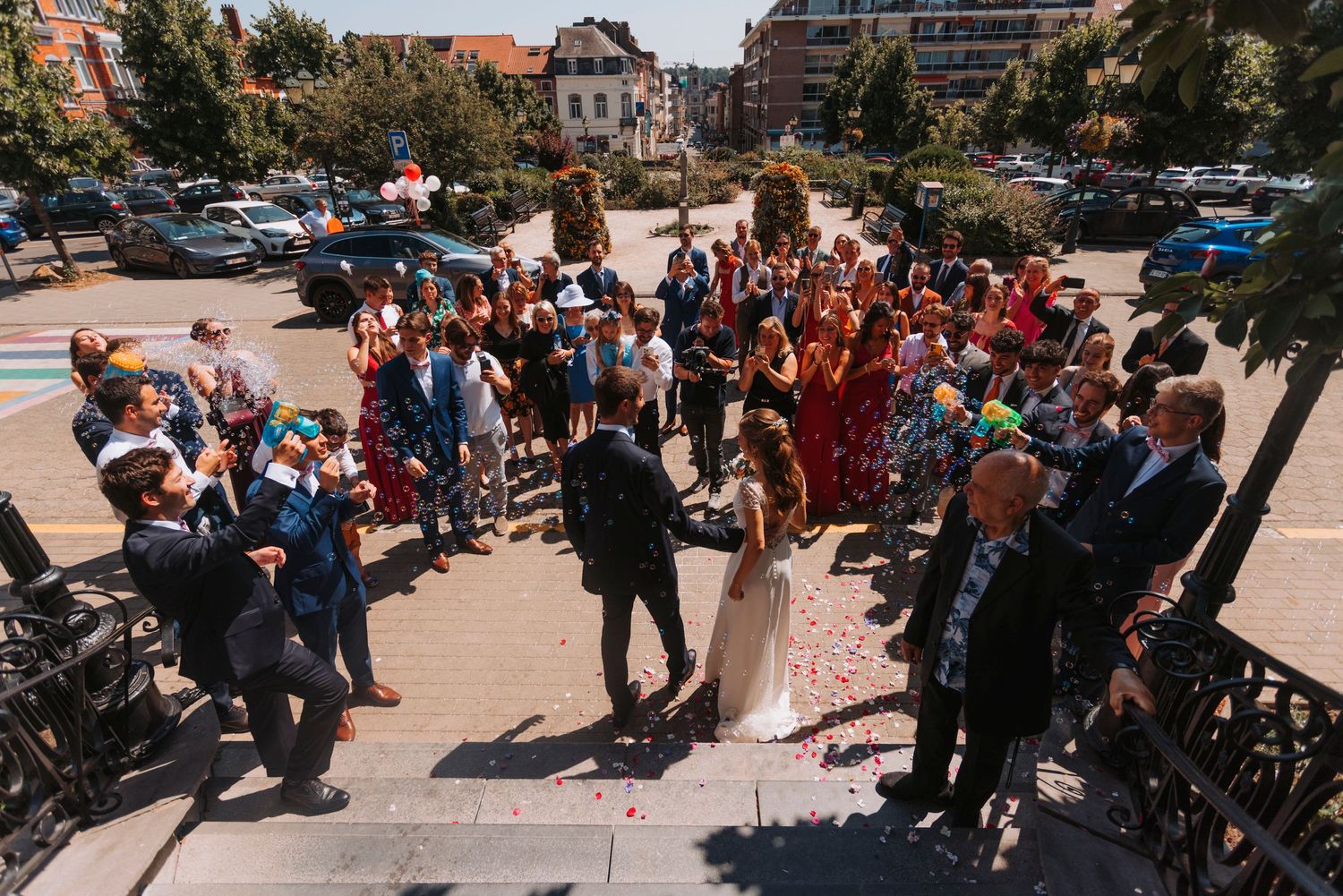Aerial view of wedding guests gathered in circular formation outdoors.