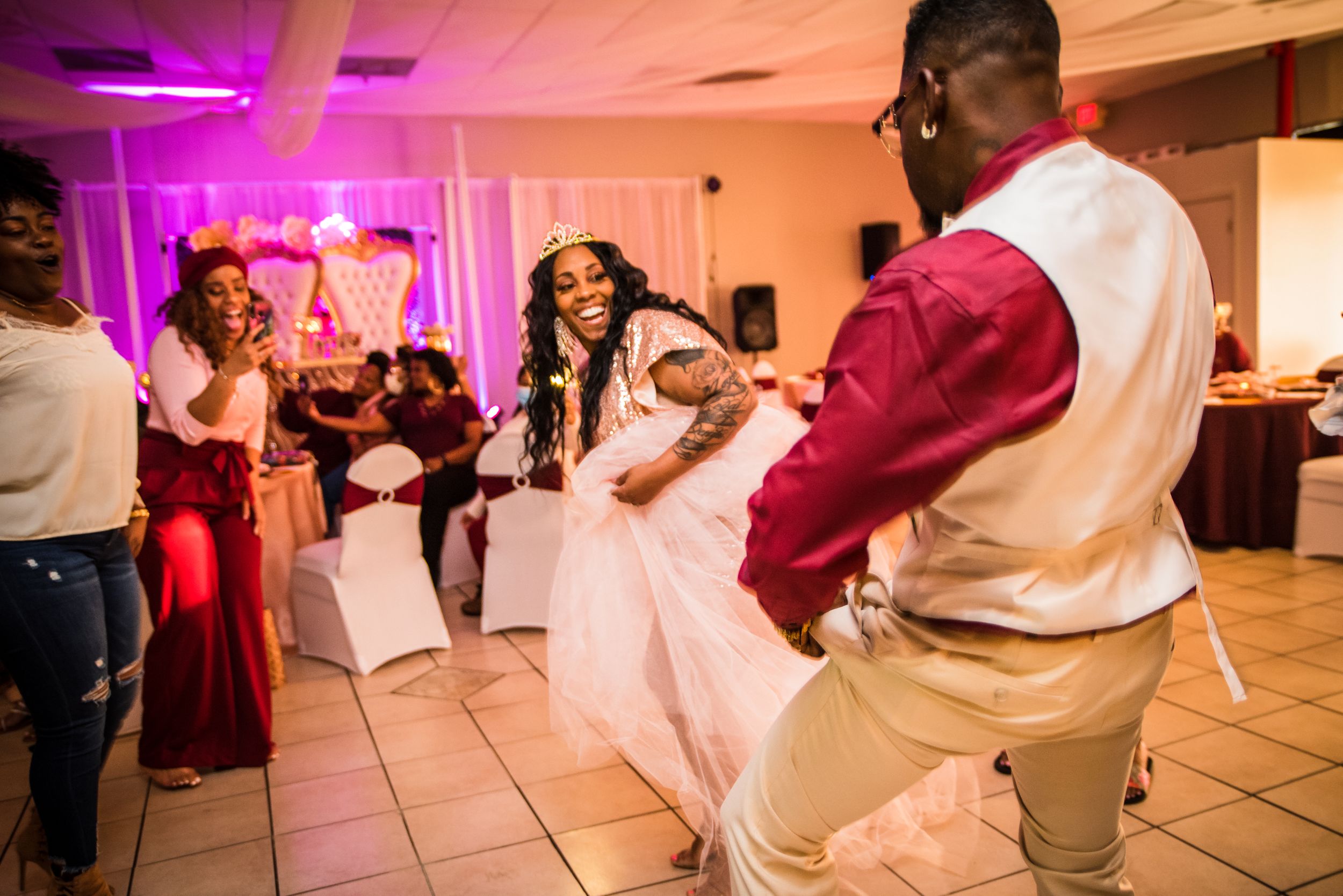 Wedding reception dance floor with purple lighting and guests enjoying the celebration.