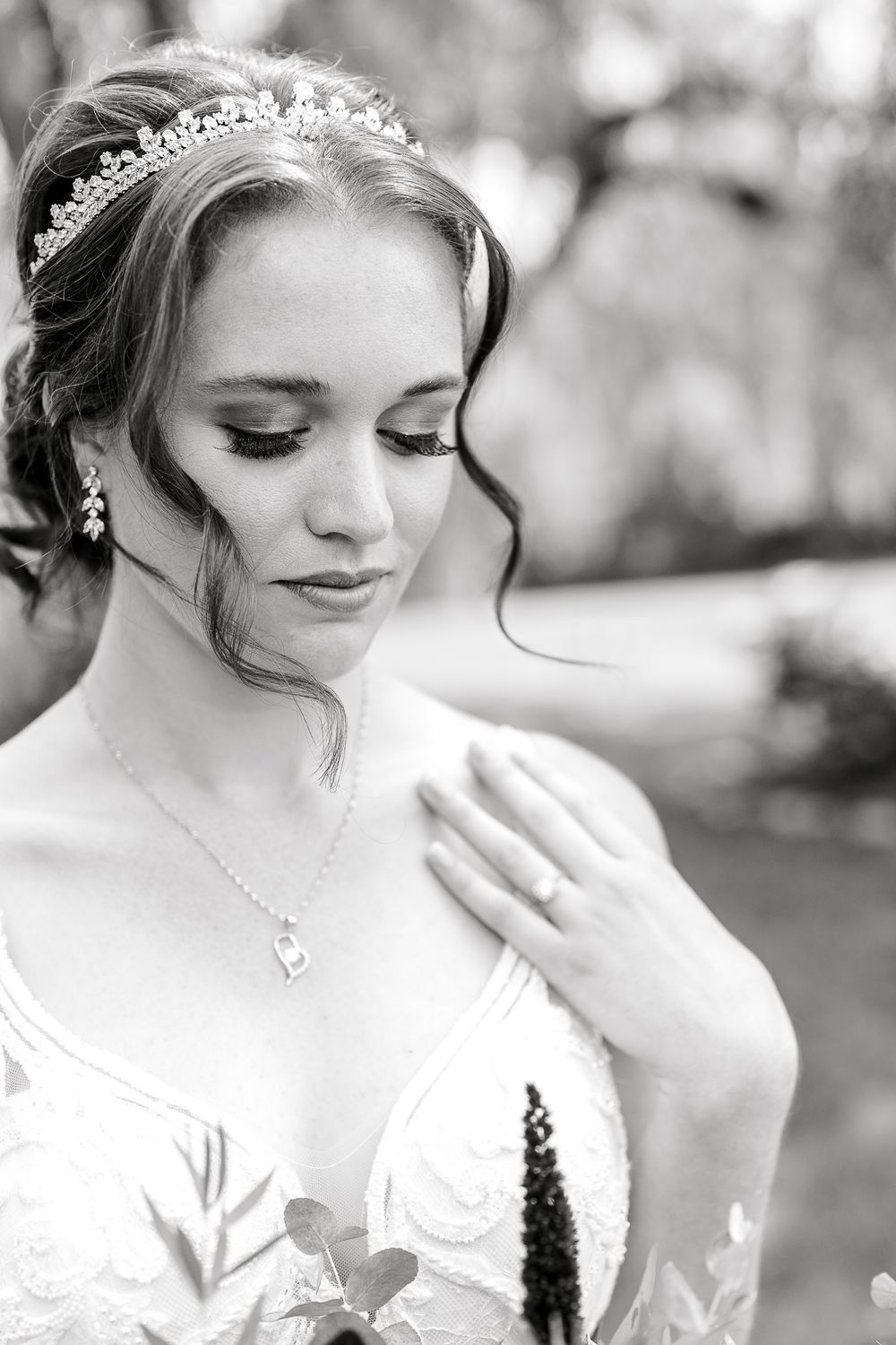 Elegant bridal portrait featuring delicate jewelry and classic makeup in black and white.
