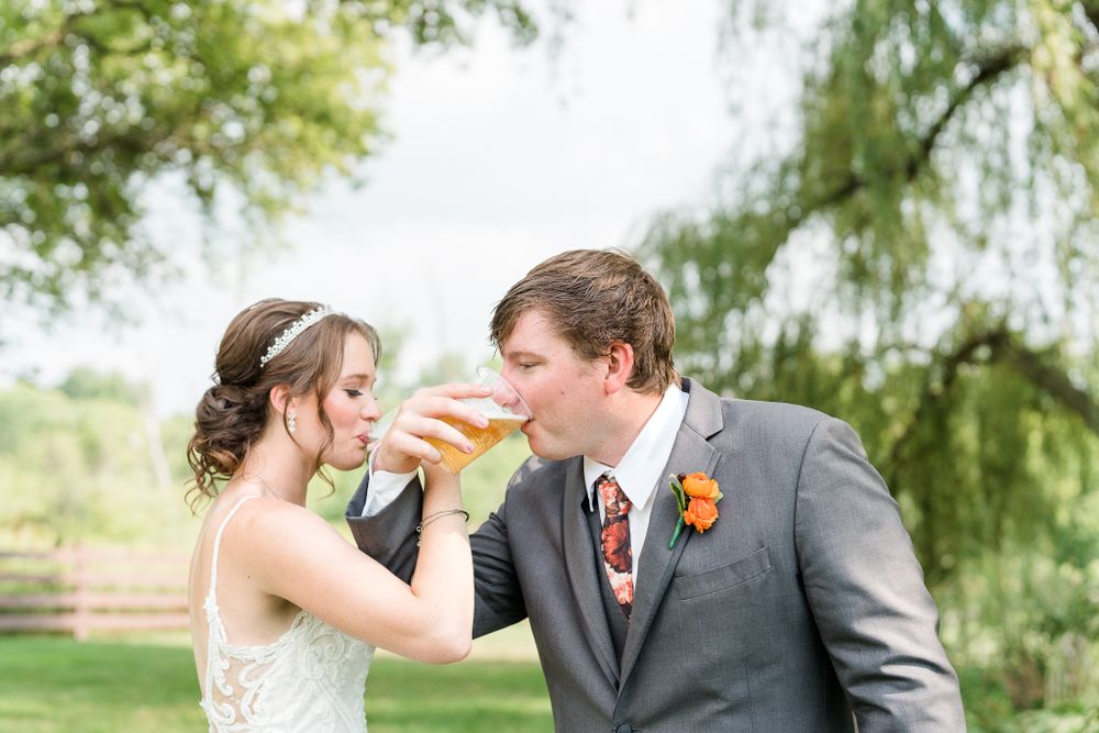 Couple shares a drink together in an outdoor garden setting.