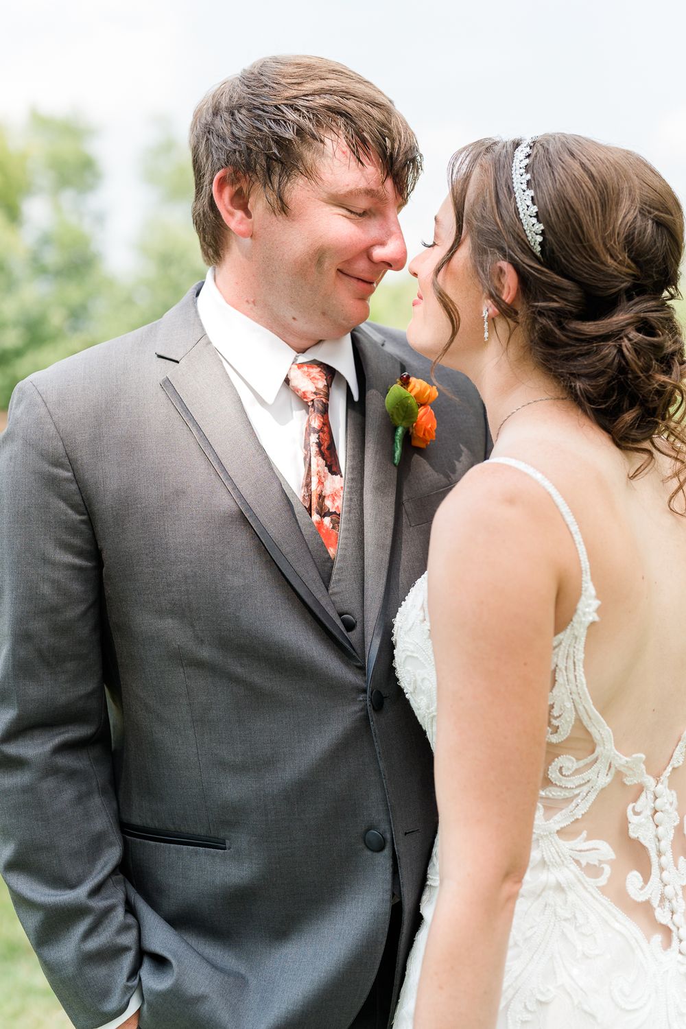 Intimate wedding portrait with couple sharing a tender moment outdoors.