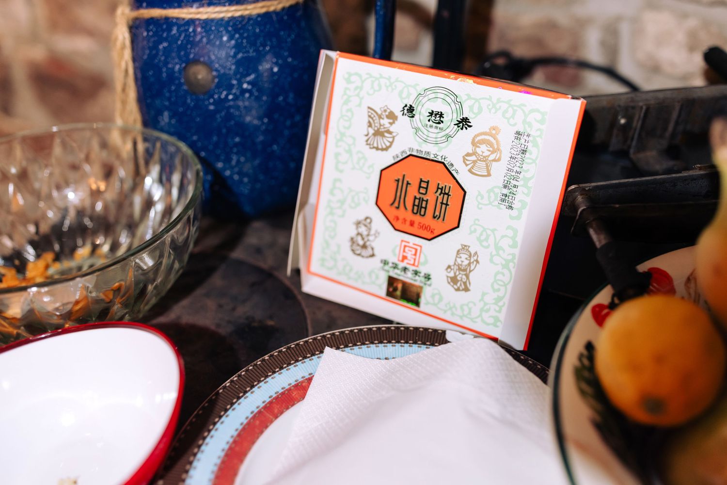Decorative wedding card with traditional Chinese designs displayed on white tablecloth.