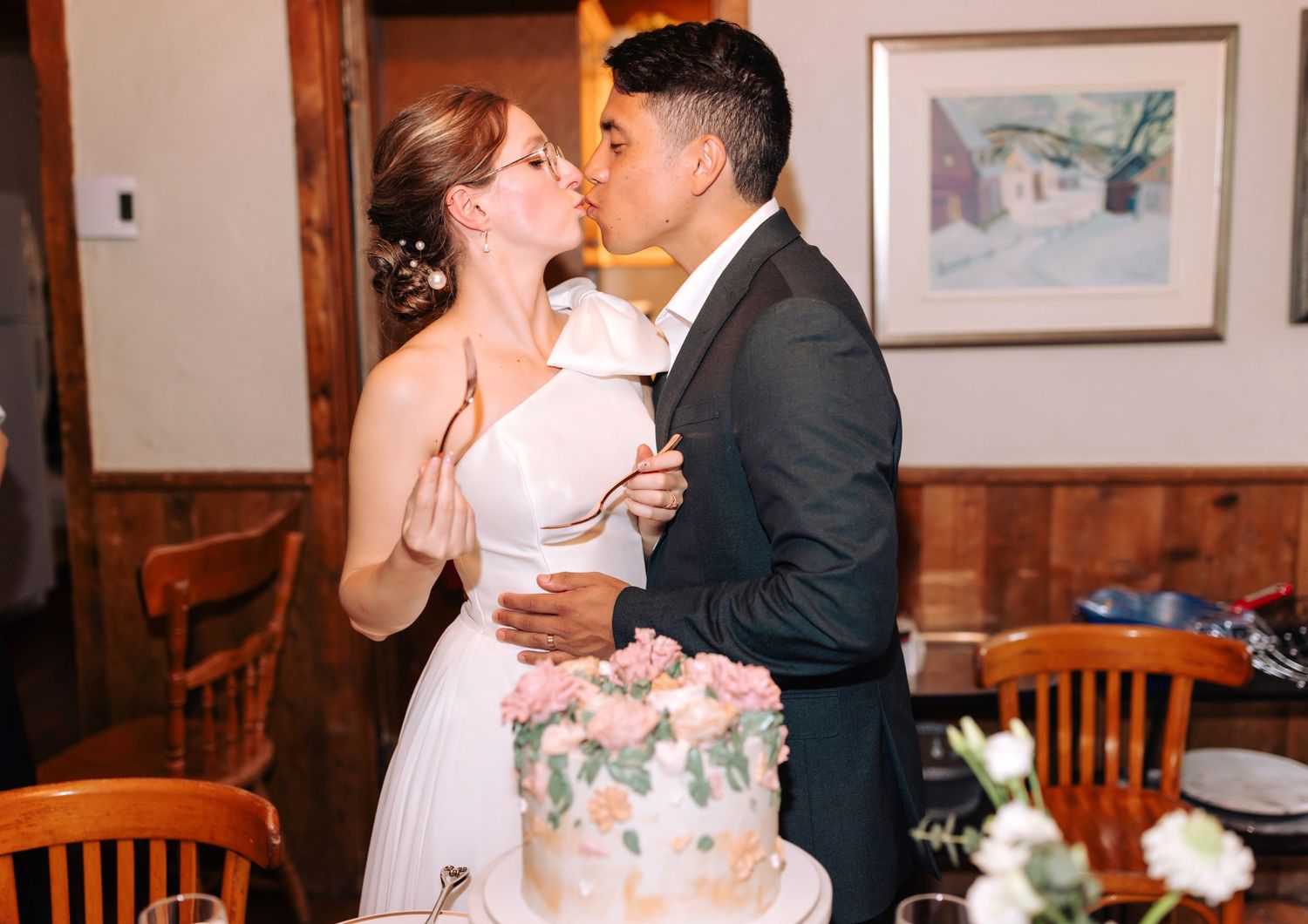 Romantic moment shared between newlyweds next to their wedding cake.