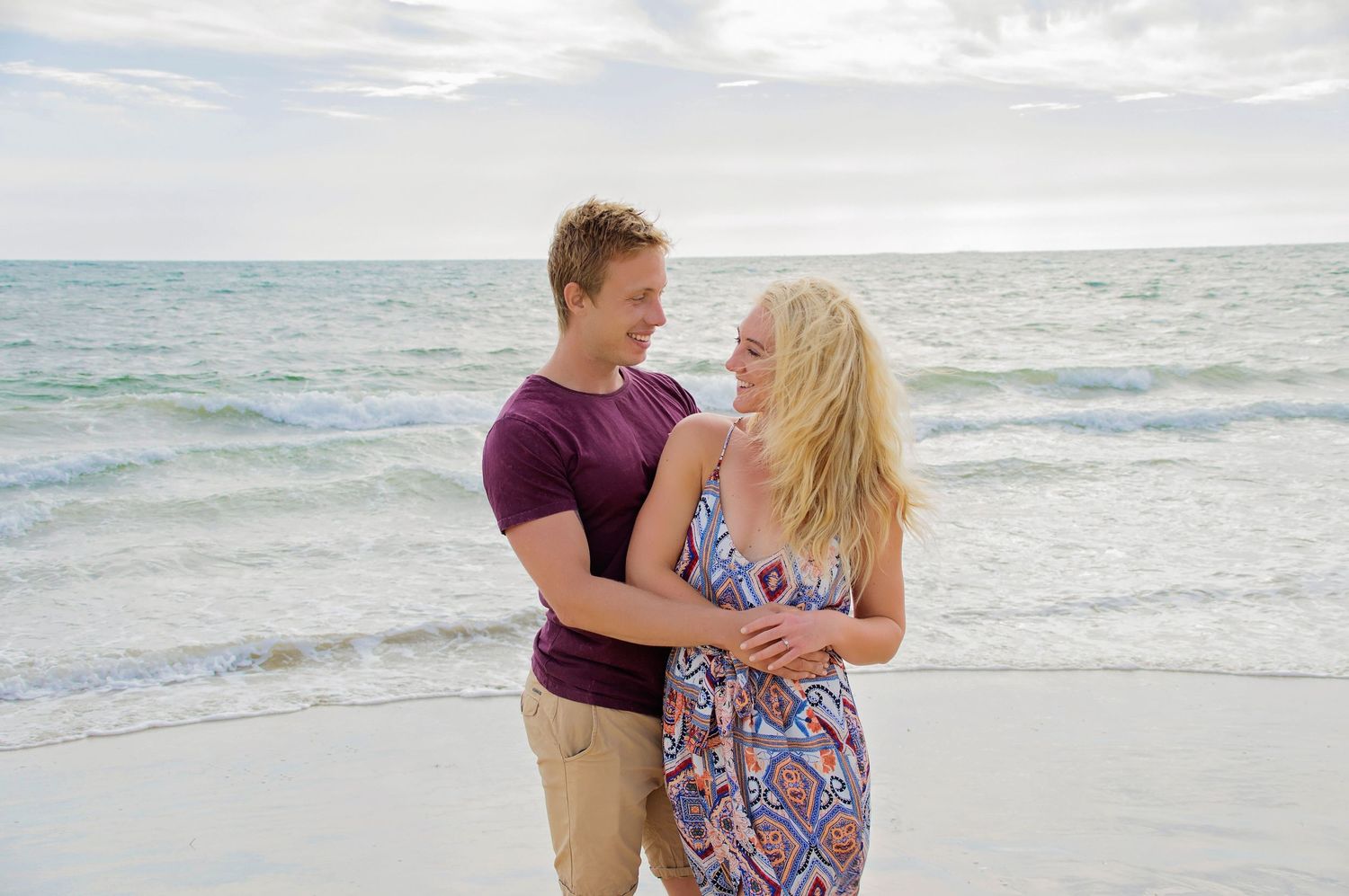 couple embracing on beach smiling
