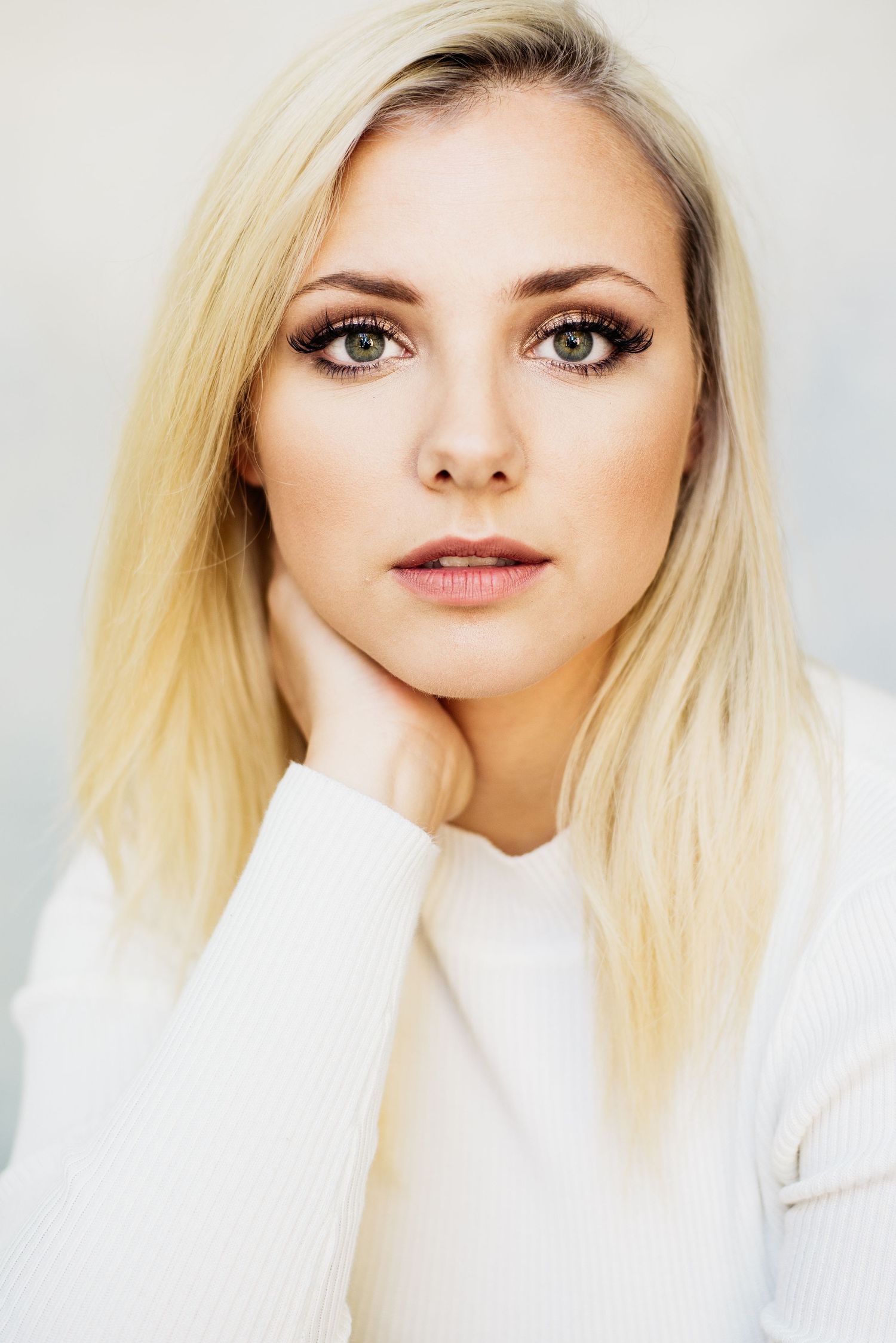 Clean beauty portrait in white sweater with natural makeup and blonde hair.