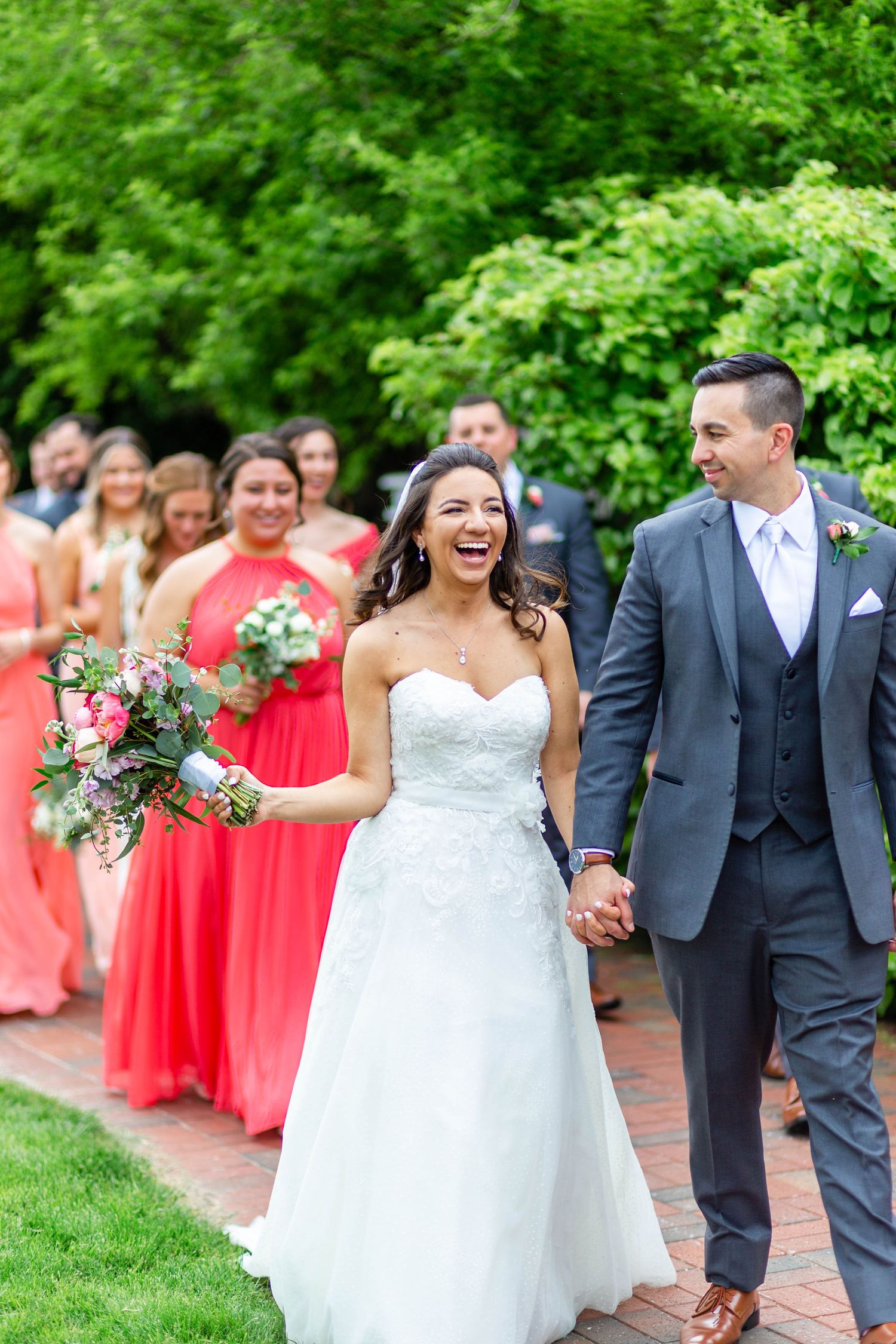 bride and groom walking with their bridal party