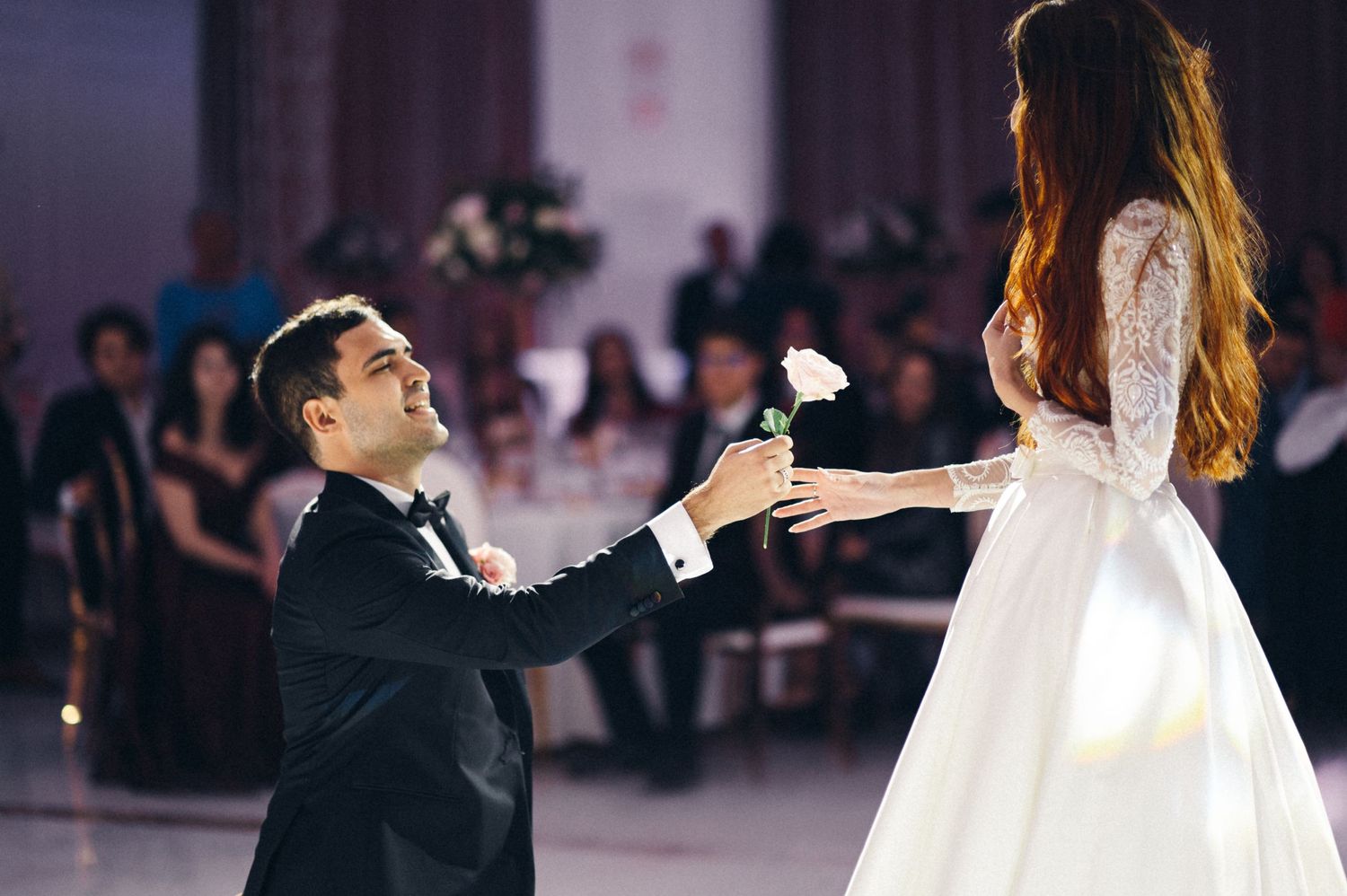 A couple shares a romantic moment during their first dance at a wedding reception.