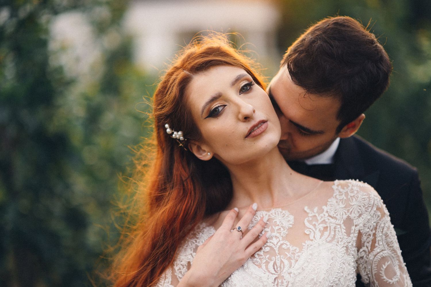 A romantic wedding portrait featuring a lace dress and intimate moment in a garden setting.