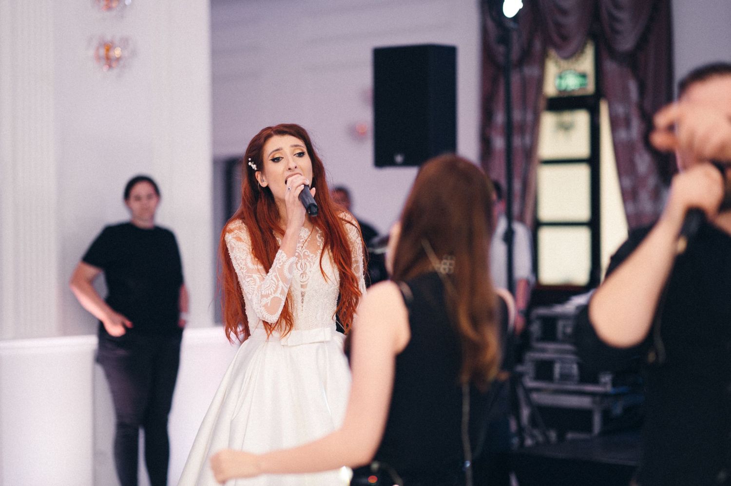 Performance at an elegant indoor venue with musicians and singers on stage.