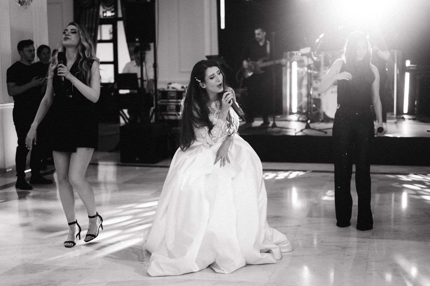 Black and white photo of entertainers performing at a formal dance event.