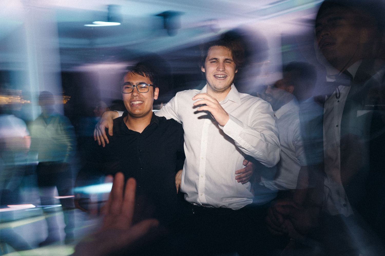 Two guests enjoying themselves at a dimly lit party with motion blur effects.