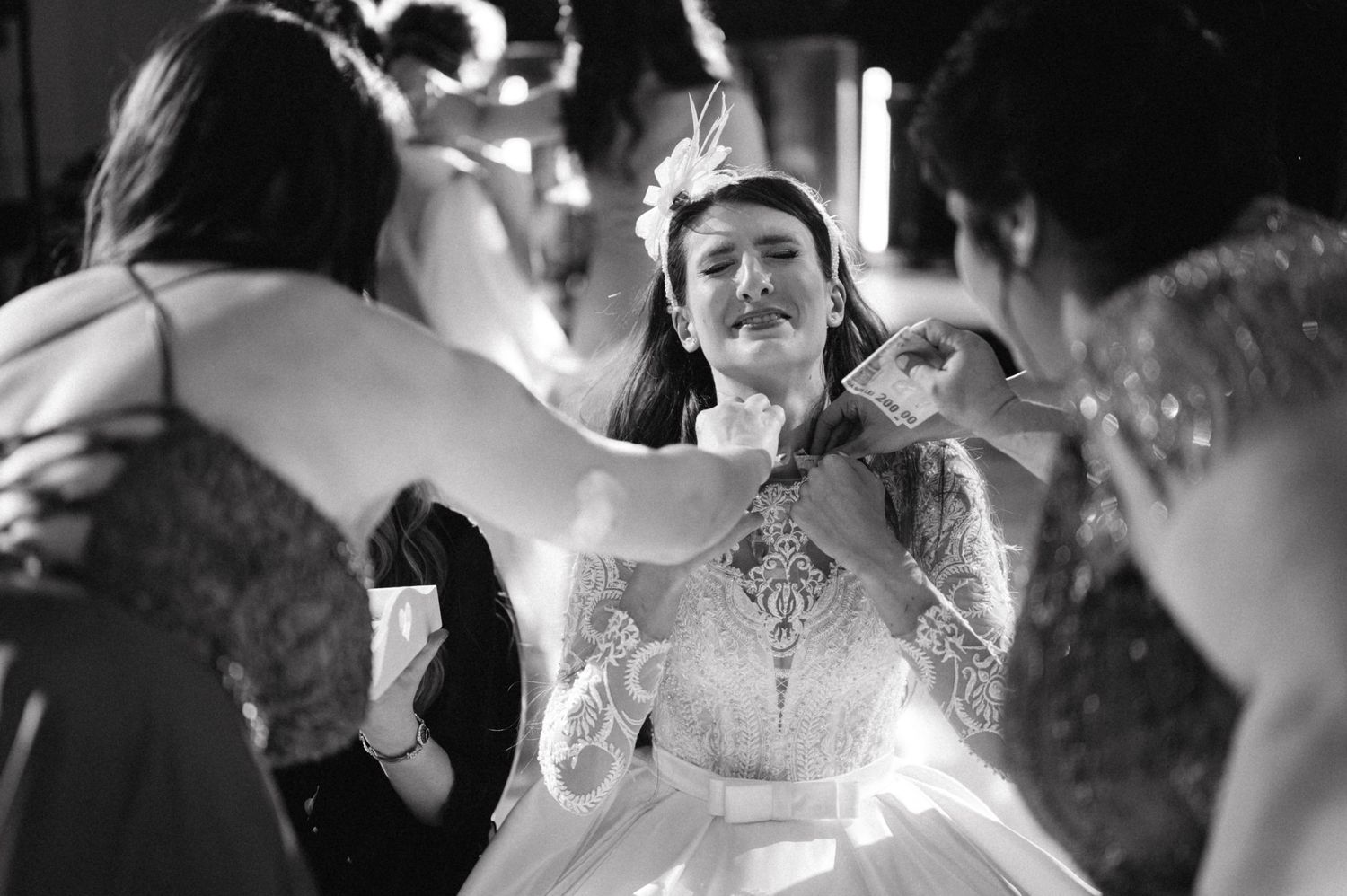 Black and white photo capturing a joyful moment at a wedding celebration.